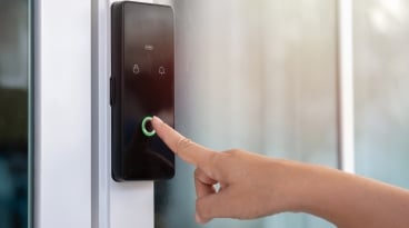 Smart Digital Touch Screen Keypad Entry Door Lock Closeup of a woman's finger entering password code on the smart digital touch screen keypad entry door lock in front of the room.