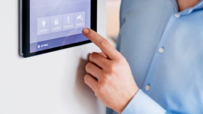 Person pointing at a tablet display with smart home screen