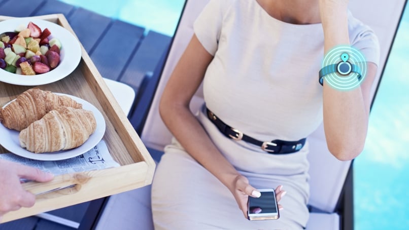 Server uses locationing to deliver food to guest who is wearing a tracking wristband medallion