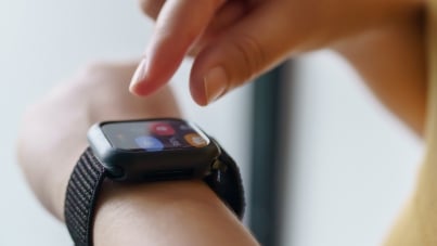 Fingers doing gesture on smart watch tied to wrist