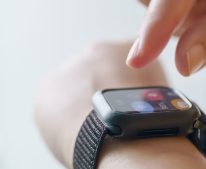 Fingers doing gesture on smart watch tied to wrist